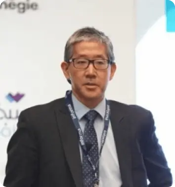 Man in a suit and tie speaking at a conference.